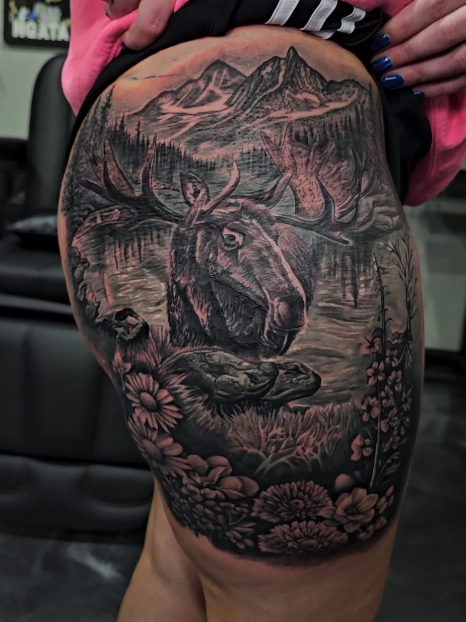 Moose wilderness scene with mountains and forest tattoo on thigh by Alex Zamora